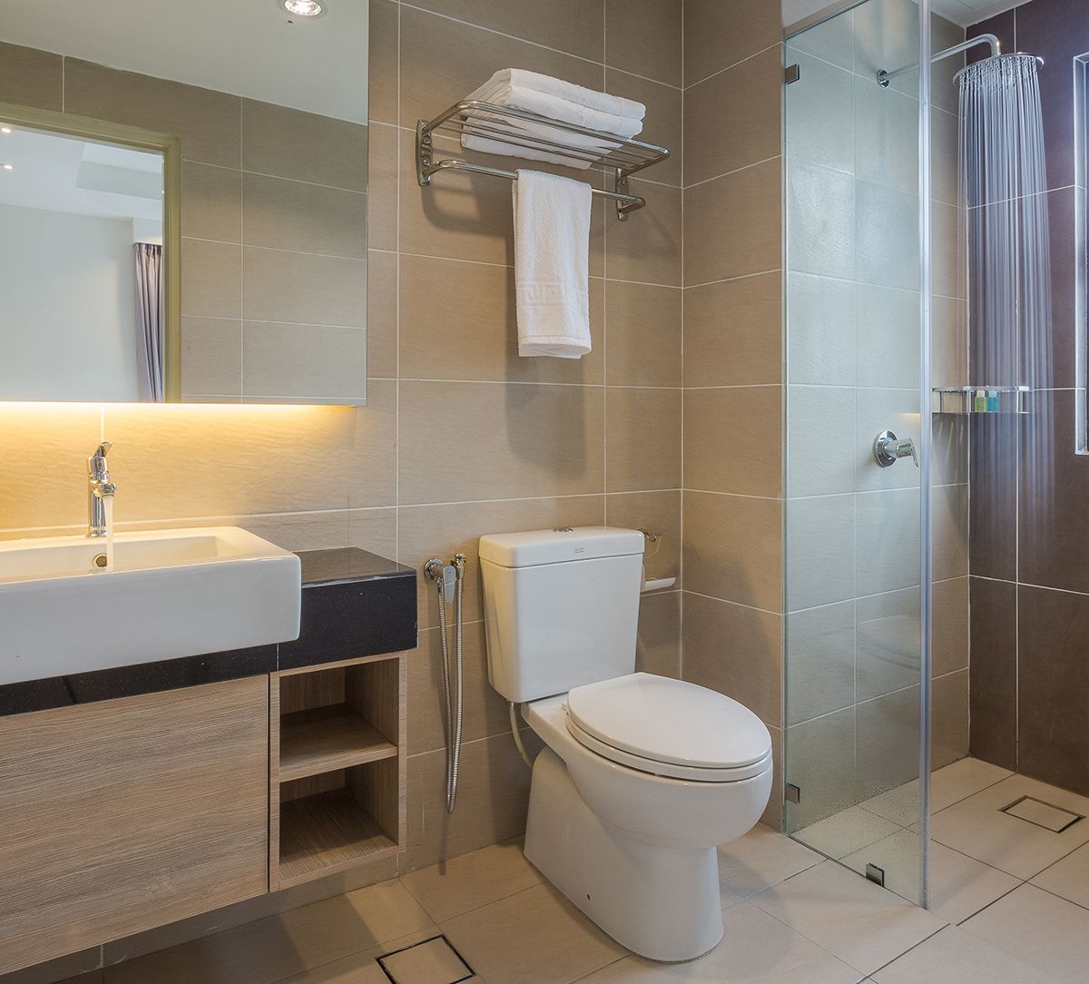 A modern bathroom with a sink, toilet, and glass shower enclosure.