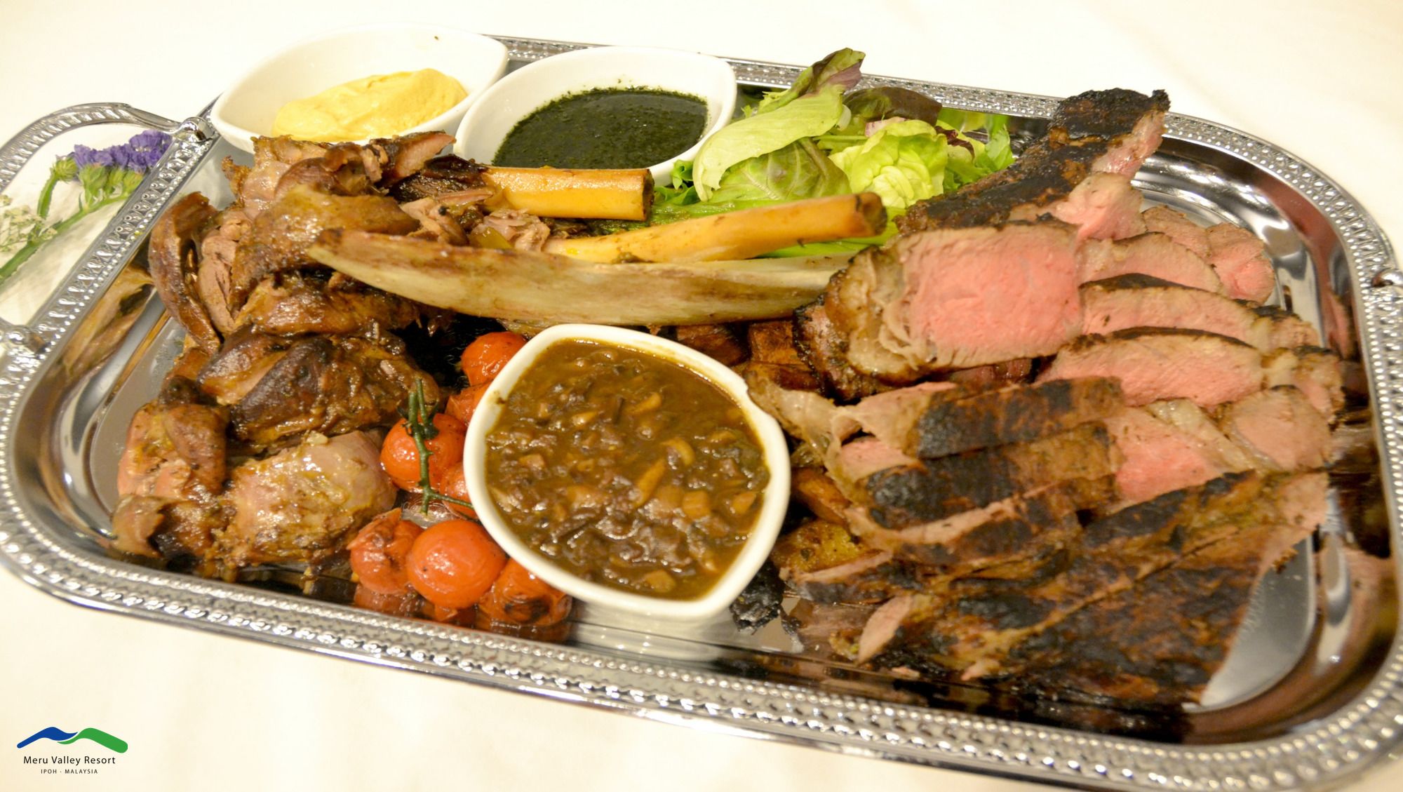 A platter with various meats, vegetables, and sauces.