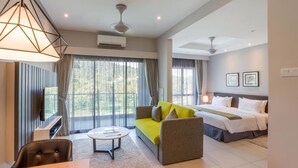 Une chambre d’hôtel moderne équipée d’un grand lit, d’un canapé, d’une table à manger et d’un téléviseur.