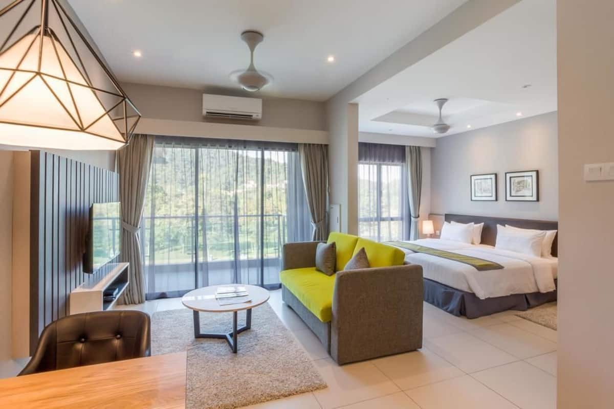 Une chambre d’hôtel moderne équipée d’un grand lit, d’un canapé, d’une table à manger et d’un téléviseur.