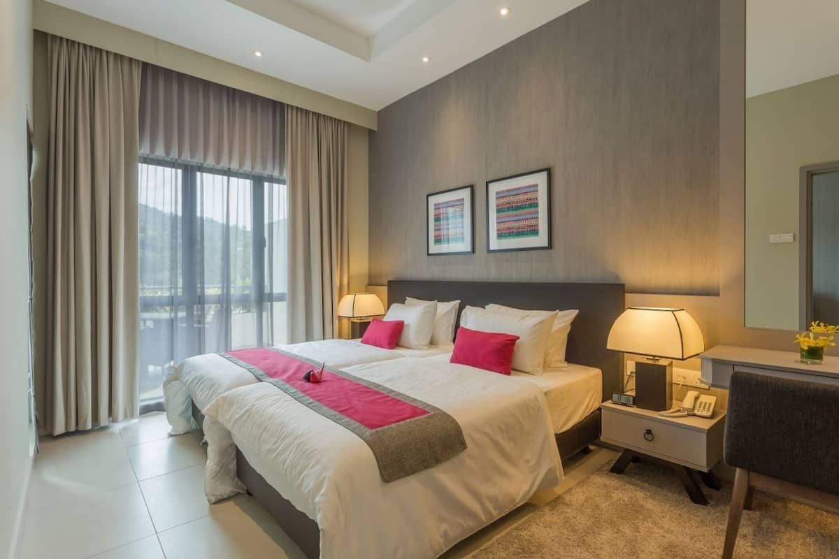 Une chambre d’hôtel avec un grand lit, deux tables de chevet, un bureau et une chaise.