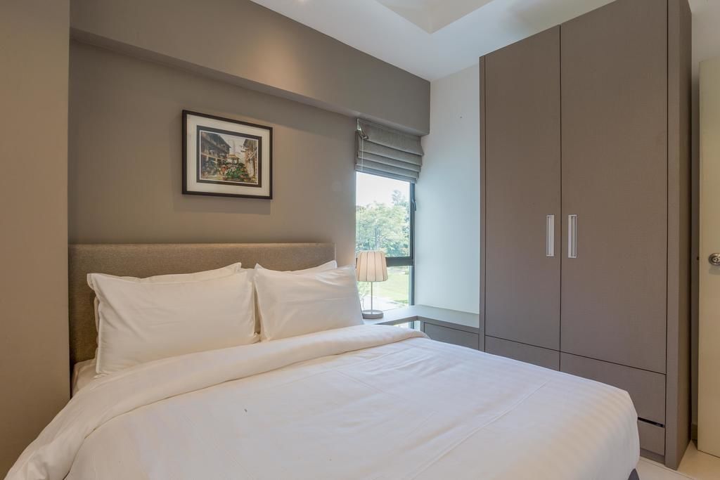 Een slaapkamer met een groot bed, een hoofdeinde, een kledingkast en een raam met uitzicht op groen.