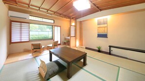 Une pièce de style japonais traditionnel, avec un sol recouvert de tatamis, une petite table en bois et des portes coulissantes.