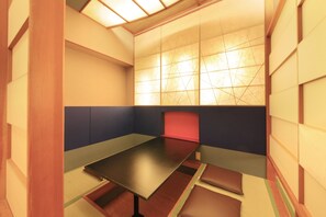 A room with a low table, cushioned seating, and a patterned wall.