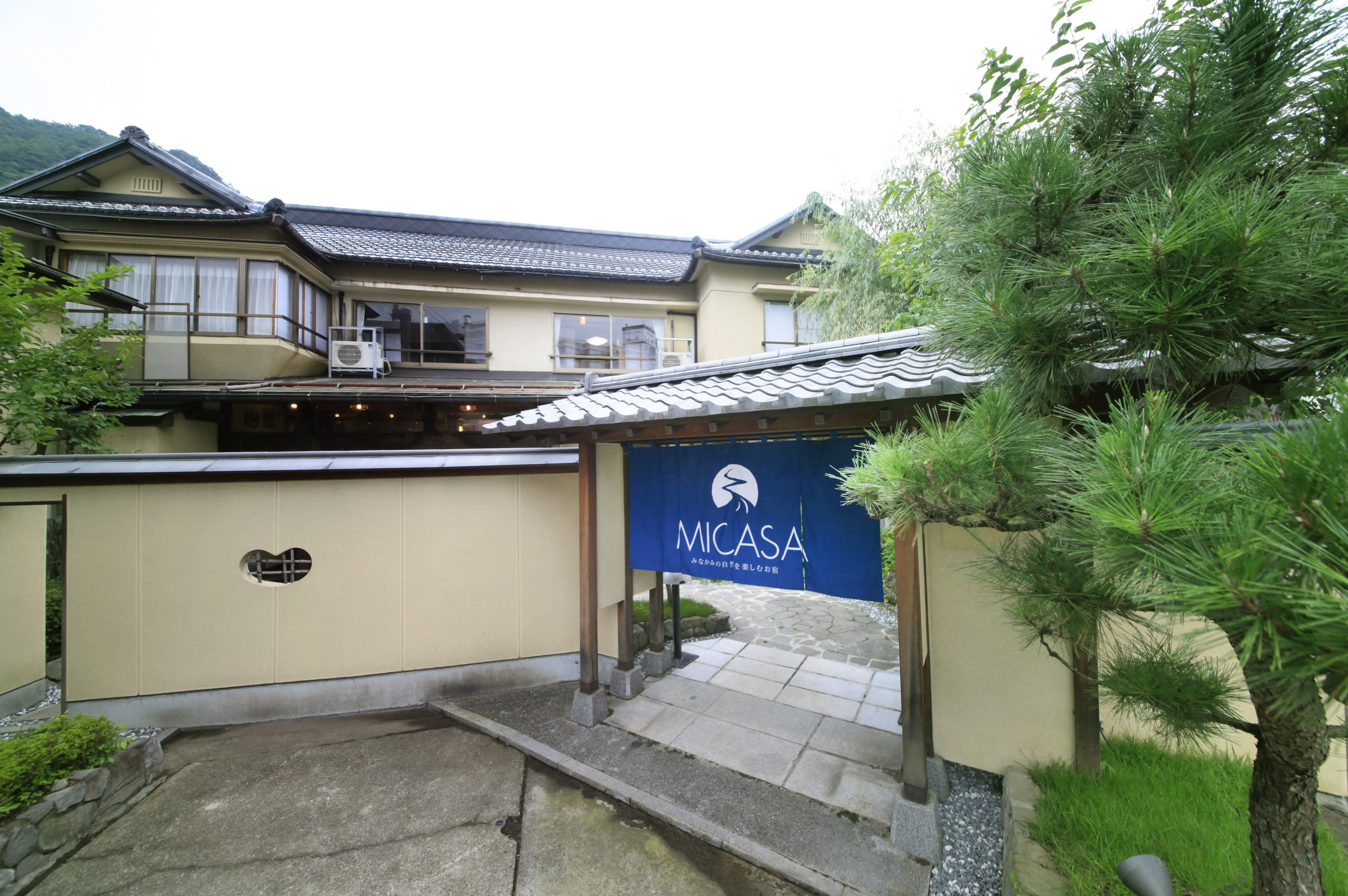 A traditional Japanese building with a tiled roof, a covered entrance, and a sign reading "MICASA".