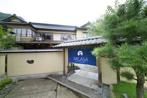 A traditional Japanese building with a tiled roof, a covered entrance, and a sign reading "MICASA".