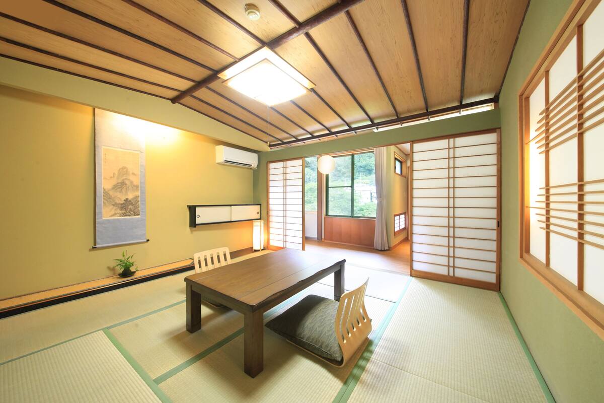 A traditional Japanese room with tatami flooring, a low wooden table, and shoji screens.