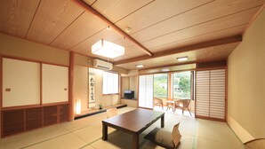 Une pièce de style japonais traditionnel, avec un sol recouvert de tatamis, une table basse et des portes coulissantes.
