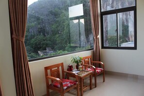 A balcony with a table, chairs, and a potted plant. - Sierra Homestay (Hoa Lu)