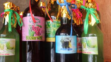 Plusieurs bouteilles de vin, décorées de rubans et d’étiquettes colorées, dont les marques « Bugnay Wine » et « Cesar’s Best ».