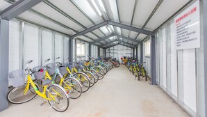 Zona cubierta de alquiler de bicicletas con filas de vehículos.