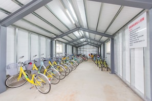 A covered bike rental area with rows of bicycles.