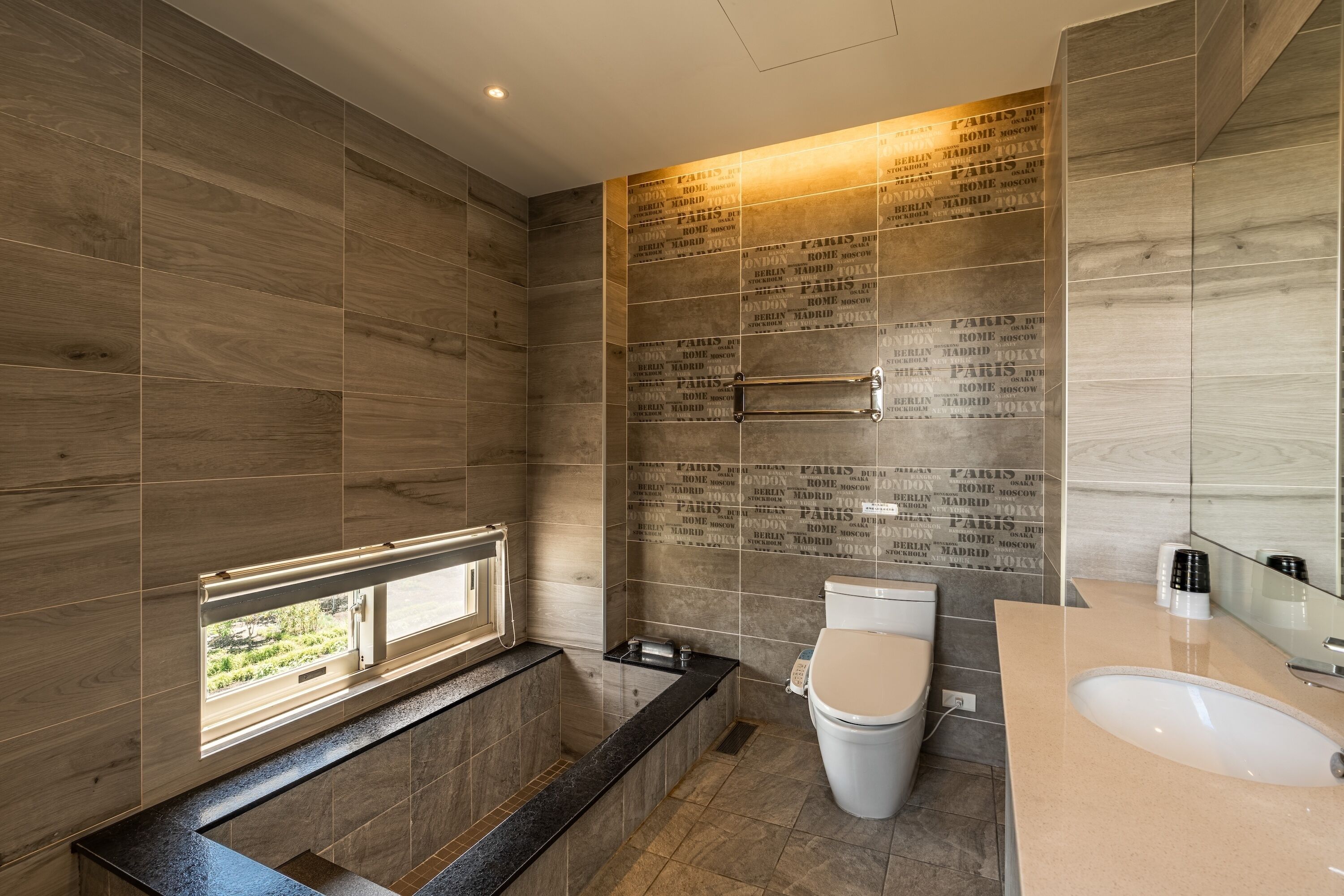 A modern bathroom with a bathtub, toilet, and sink.