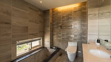 A modern bathroom with a bathtub, toilet, and sink.