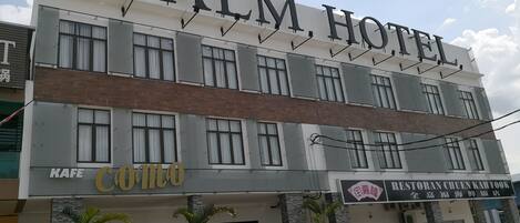 Un hotel de varios pisos con un letrero llamativo que dice "PALM HOTEL".
