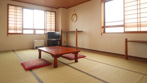 Une pièce de style japonais traditionnel, avec un sol recouvert de tatamis, une basse table en bois et des portes coulissantes.