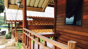 A wooden house with a porch, a window, and a metal roof. - Janya Homestay (Ko Yao)