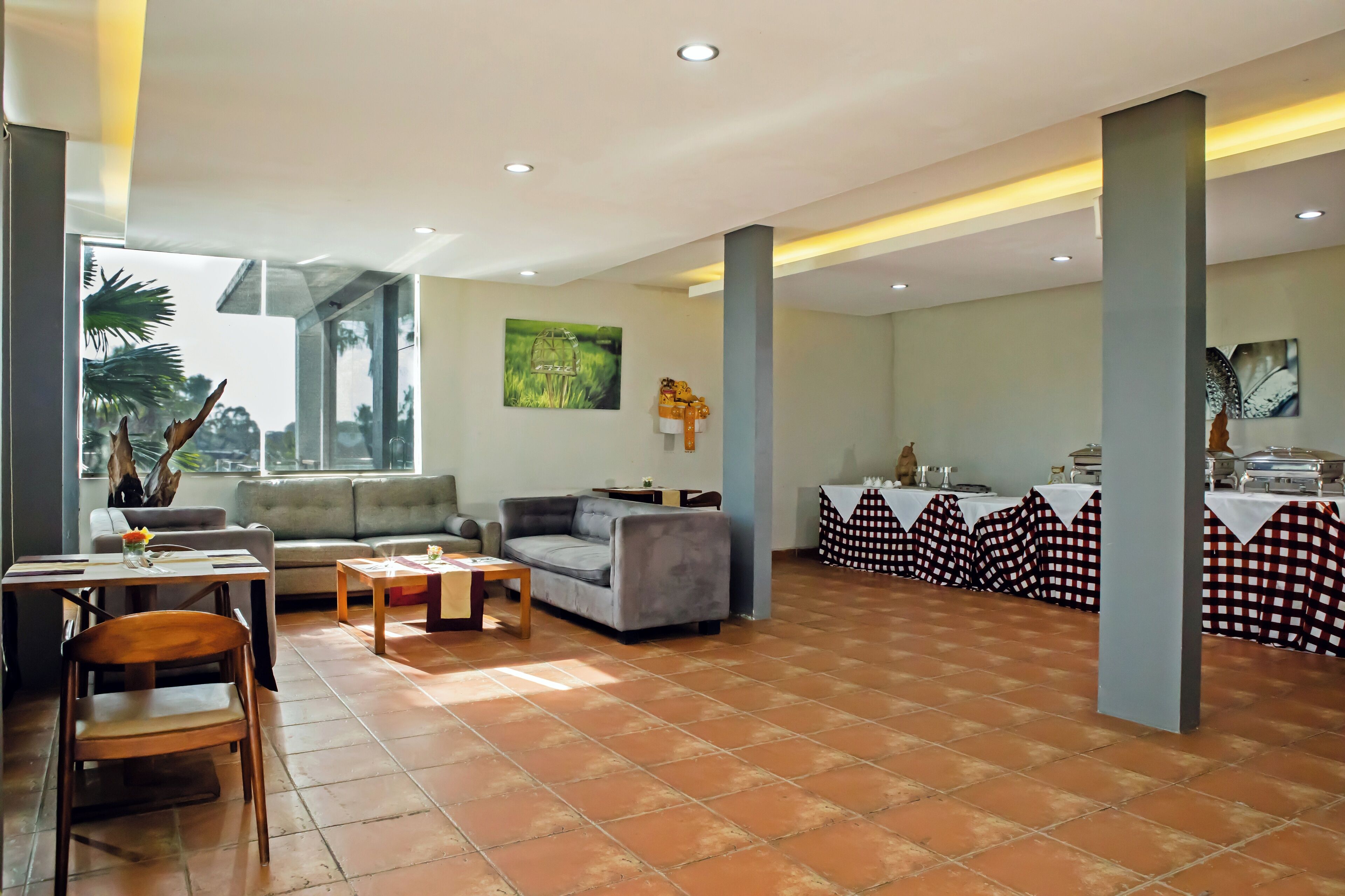 A spacious lobby with a dining area, sofas, and a bar.
