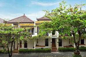 Un edificio tradicional con techo de tejas, un patio y un jardín bien cuidado.