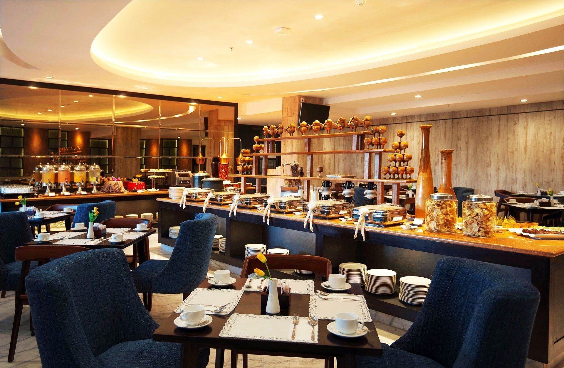 A modern restaurant with a bar area, multiple seating options, and a variety of food and drink displays.