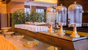 A buffet setup with food dispensers, serving trays, and a decorative bowl. - Waifiden Apartment Pazhou Complex (Guangzhou)