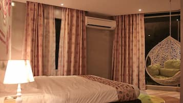 Quarto moderno com cama, cadeira suspensa e aparelho de ar condicionado.