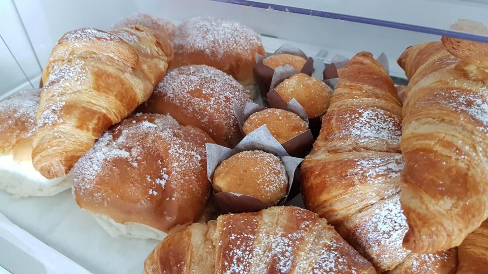 Forskellige slags kager og wienerbrød, blandt andet croissanter og luksusflødeboller, nogle drysset med flormelis.