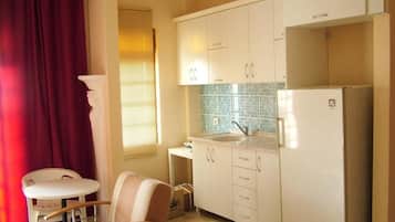 Full-sized fridge, stovetop, electric kettle, cookware/dishes/utensils