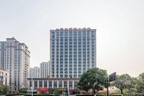 A high-rise building with a modern architectural style, surrounded by trees and other buildings. - Liang an International Hotel (Hangzhou)