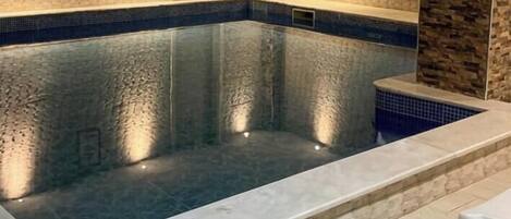 A swimming pool with a textured wall and a clear water surface.