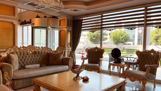 A luxurious room with ornate furniture, a chandelier, and large windows offering a view of the street. - Ottoman Hotel Sakarya (Adapazari)