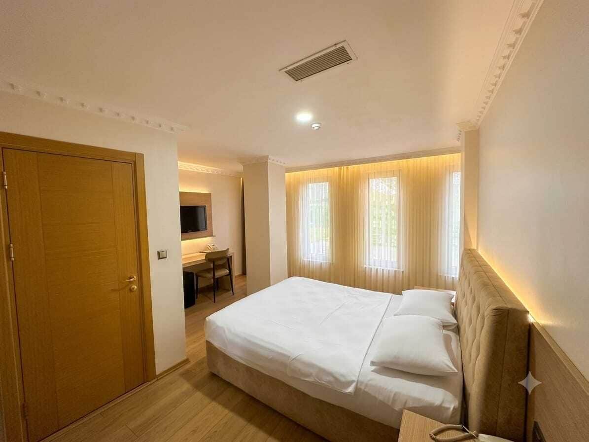 Una habitación de hotel con cama, escritorio y televisor.