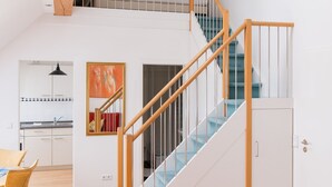 Un interior moderno con una escalera de madera, un comedor y una cocina.