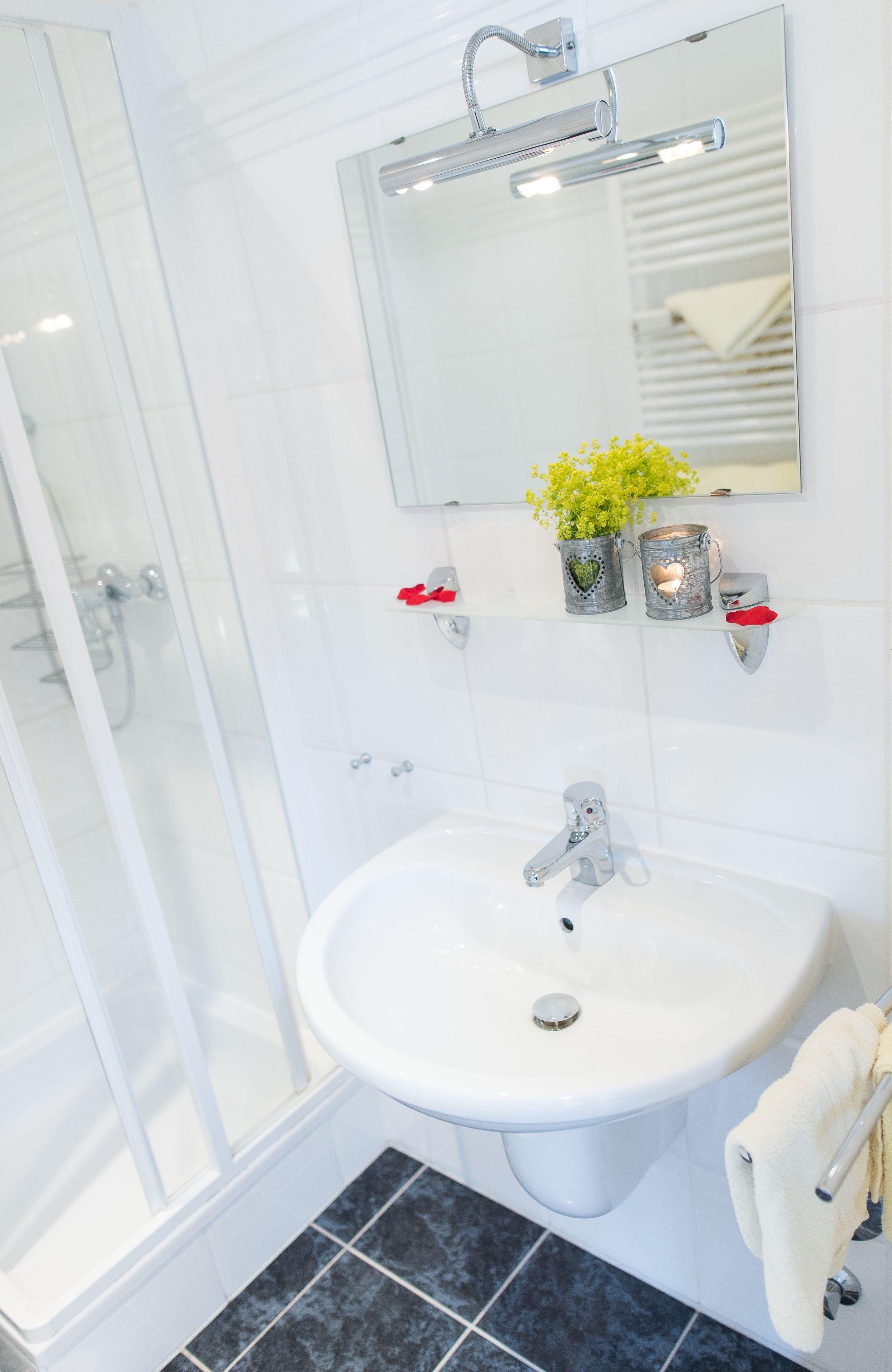 A bathroom with a white sink, a glass shower enclosure, and a mirror above the sink.