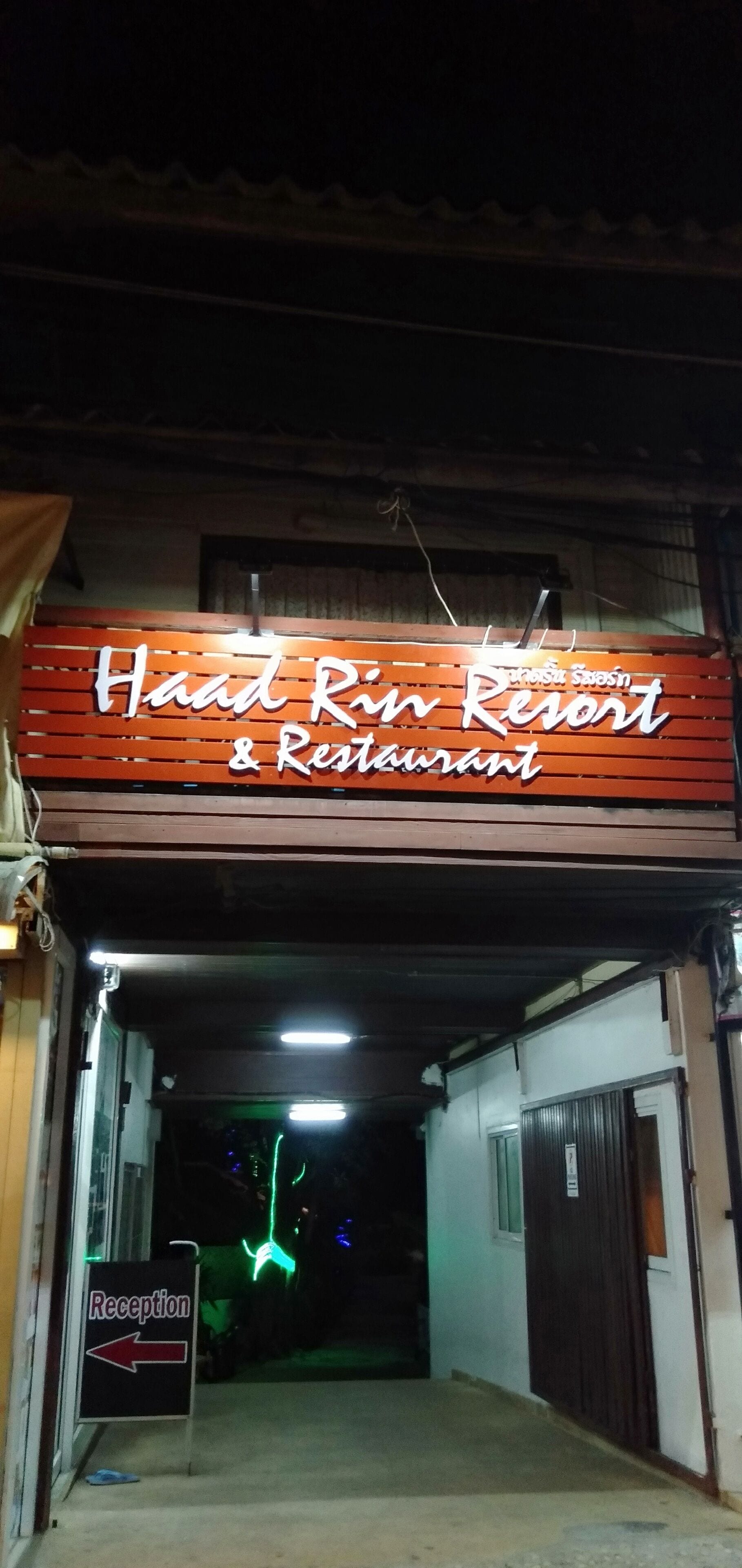 A sign for Haad Rin Resort & Restaurant with a reception sign below it.