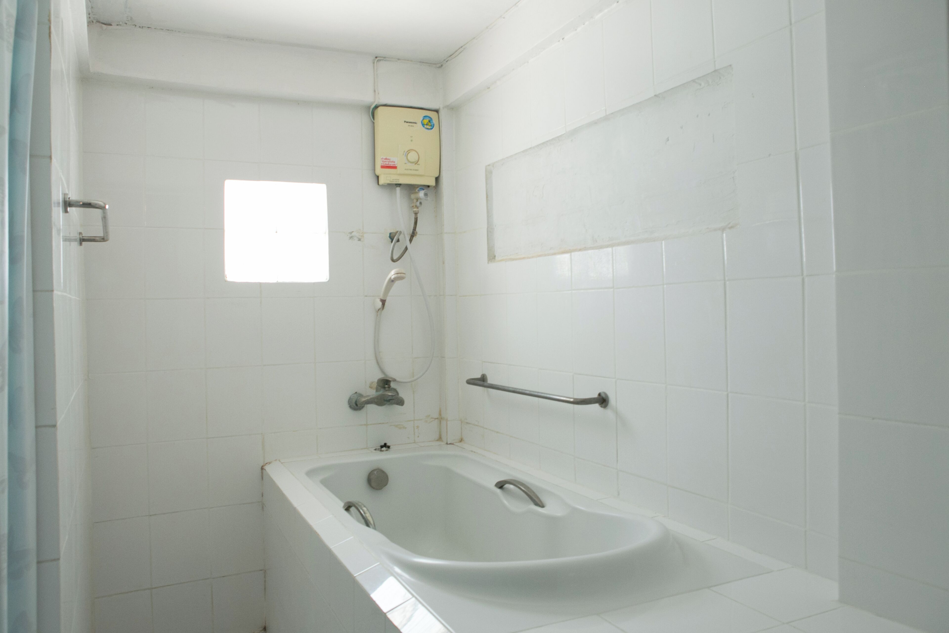 A bathroom with a bathtub, a shower, and a window.