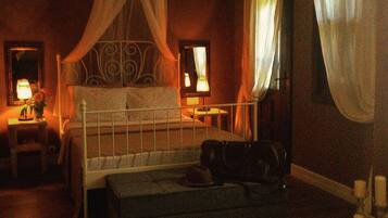 A dimly lit room with a bed, a bedside table, and a lamp.