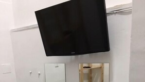 A bathroom with a mounted TV, three mirrors, and a white bench. - Almayer La Locanda della Bicicletta (Gaeta)