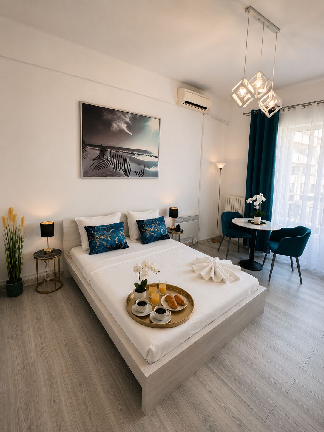 Ein modernes Hotelzimmer mit einem großen Bett, einem Essbereich und Blick ins Freie.