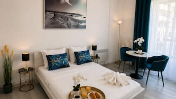 Ein modernes Hotelzimmer mit einem großen Bett, einem Essbereich und Blick ins Freie.