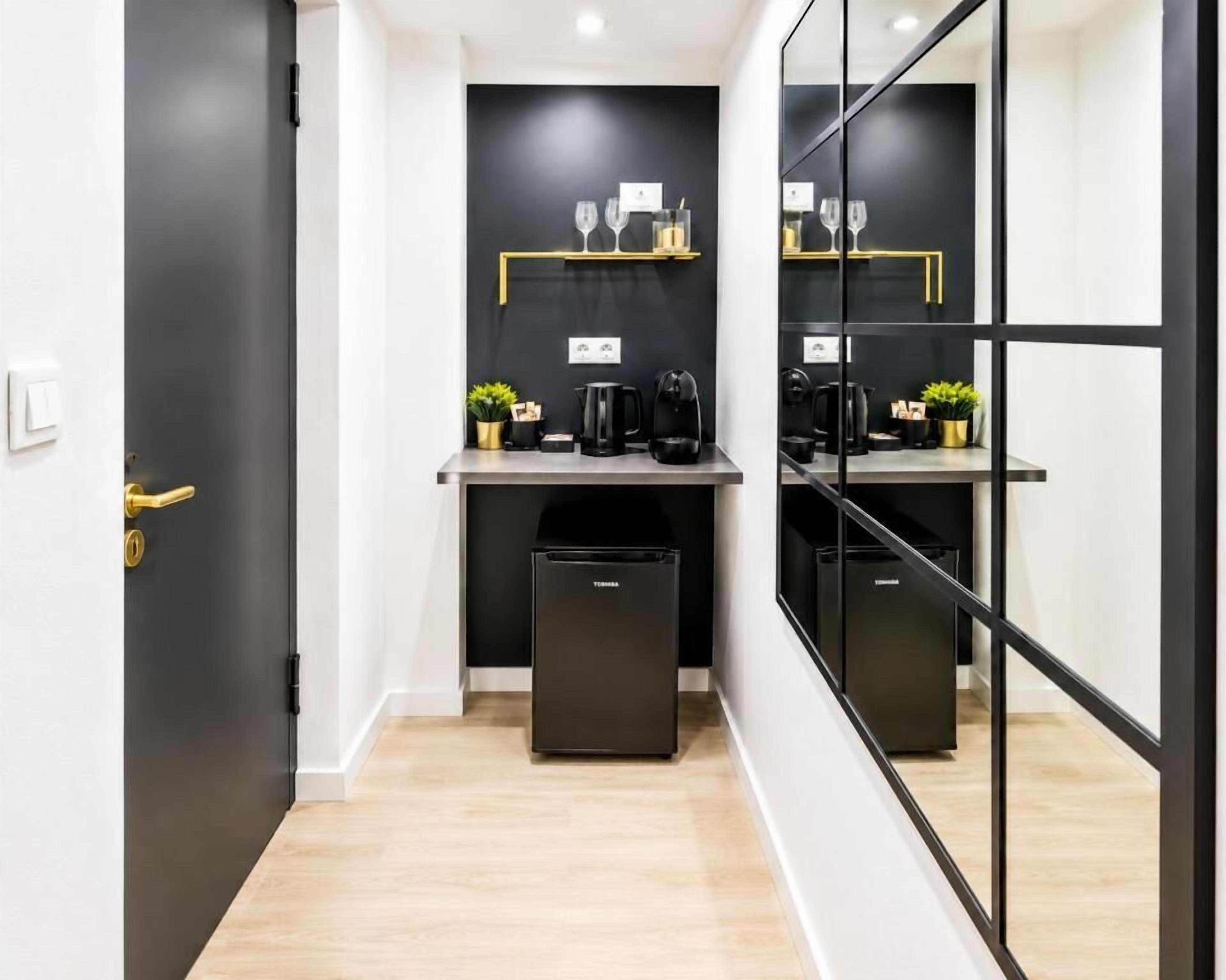 Una cocina moderna con gabinetes negros, una encimera y un cubo de basura negro.