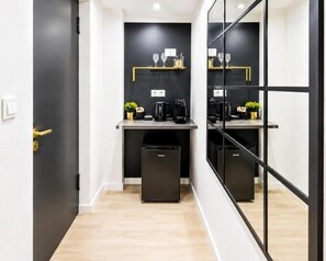 A modern kitchen with black cabinets, a countertop, and a black trash bin. - Metropole Apartments Old City (Bucharest)