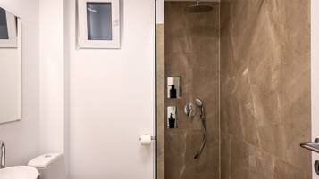 Un baño moderno con ducha de vidrio, inodoro y lavamanos.