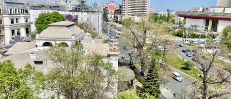 Paisagem urbana com um hotel em destaque, uma rua movimentada e edifícios ao redor.