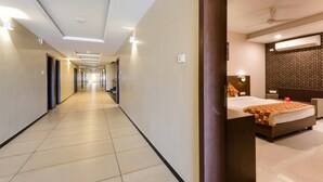 A hotel corridor with a bed and a bathroom visible. - Hotel Park Palace (Ujjain)