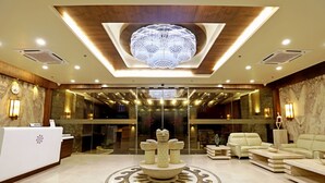 A lobby with a reception desk, a central decorative fountain, and seating areas. - Vits Devbhumi Hotel (Dwarka)