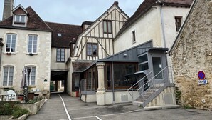 A narrow street with traditional buildings, a visible entrance, and a no parking sign. - Logis Relais Saint Vincent (Ligny-le-Chatel)