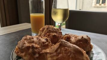 A plate with pastries and two glasses of beverages on a table.