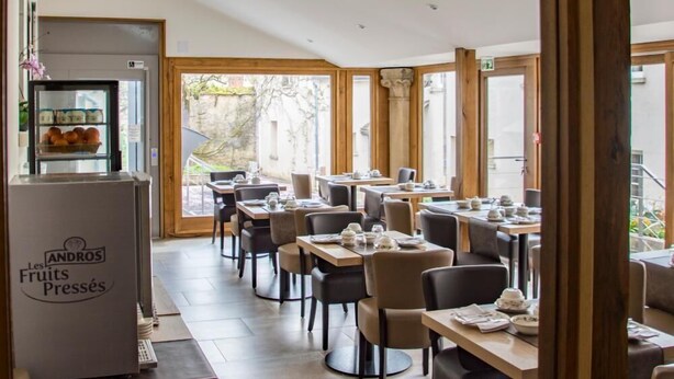 A restaurant with a modern interior, featuring wooden beams, large windows, and a variety of seating arrangements. - Logis Relais Saint Vincent (Ligny-le-Chatel)