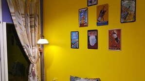 A room with a glass table, a bench, and a wall decorated with vintage posters. - Pottery B&B (Jiaoxi)